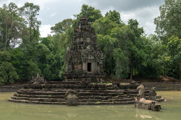 Circular stone monument with doorway in pond