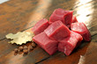 Mięso na gulasz z szynki wieprzowej. Kompozycja mięsa z przyprawami na drewnianej desce.