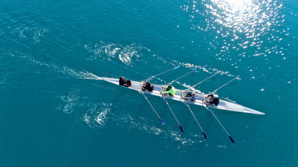 Wall Mural - Aerial drone bird's eye view of sport canoe operated by team of young men in open sea