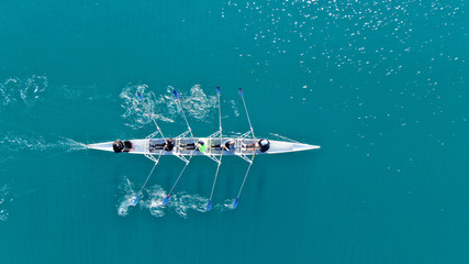 Wall Mural - aerial drone bird's eye view of sport canoe operated by team of young men in open sea