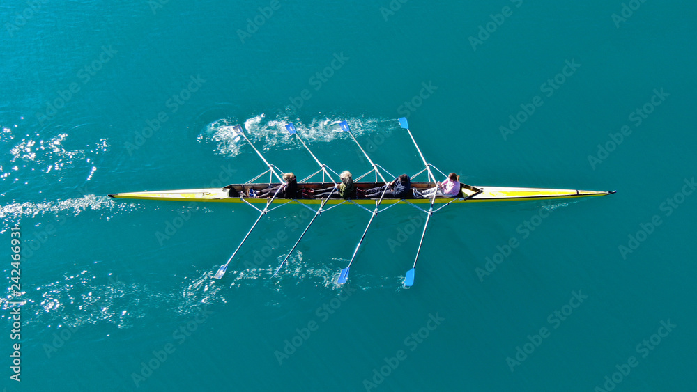 Aerial drone bird's eye top down view of sport canoe operated by team of young men in open ocean emerald sea - obrazy, fototapety, plakaty 