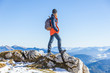© Westend61 - Female hiker standing on cliff against clear blue sky