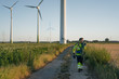 © Westend61 - Technician walking on field path at a wind farm with climbing equipment
