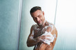 © Yakobchuk Olena - Handsome young man washing himself with shower gel