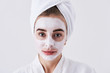 © Yakobchuk Olena - Cute girl with purifying mask on her face standing against white background