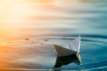Close-up Of Simple Small White Origami Paper Boat Floating Quietly In Blue Clear River Or Sea Water Under Bright Summer Sky. Freedom, Dreams And Fantasies Concept, Copyspace Background.