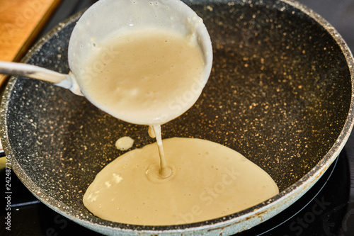 Fotografia Pouring pancake dough on frying pan