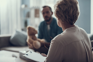 Wall Mural - Rare view of the woman sitting with clipboard in front of man