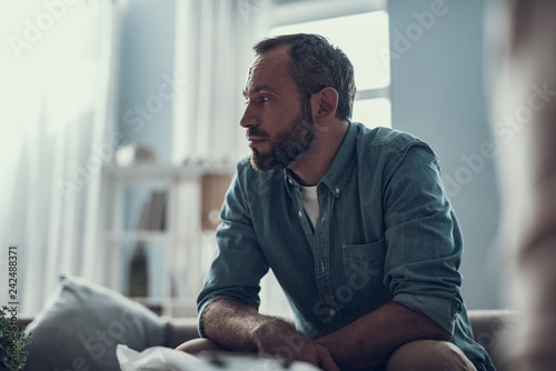 Fotografía Waist up of bearded man thoughtfully looking away