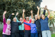 Gruppo di anziani felici che sollevano le braccia al cielo e ridono