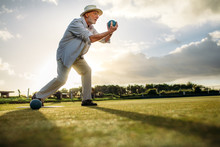 Side View Of An Elderly Man Playing Boules