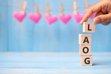 Wall Mural - GOAL wooden cubes with pink heart shape decorationon on blue table background with copy space for text. Business, Mission, Core Value, Solution and Happy Valentine’s day holiday concept