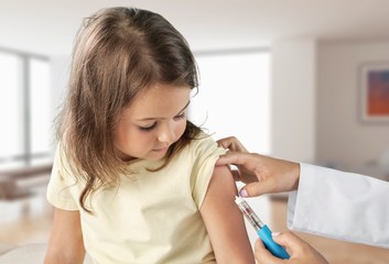 Wall Mural - Doctor vaccinating little girl isolated on a white background