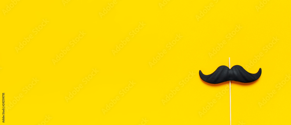 Black mustache, props for photo booths, carnival, parties on yellow background top view flat lay copy space. Father's day, Creative party decoration concept. Men's health awareness month - obrazy, fototapety, plakaty 