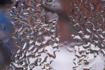 Water drops on glass window close up with blurred background. Drops in macro. Condensate on window closeup. Wet air.