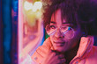 © ADDICTIVE STOCK - Black woman standing on night city street