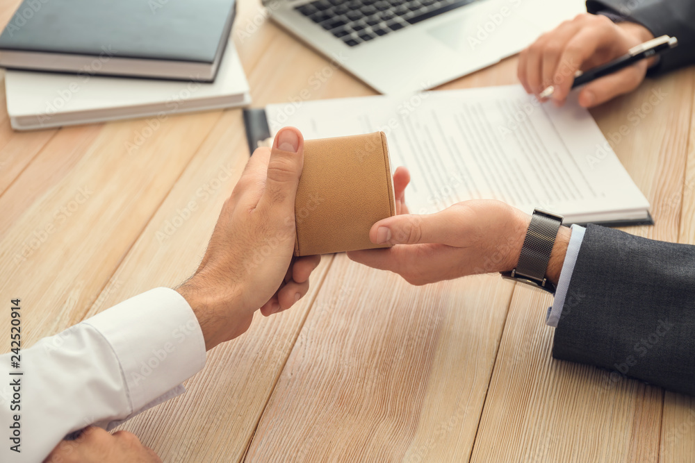 Man giving bribe to businessman in office. Concept of corruption