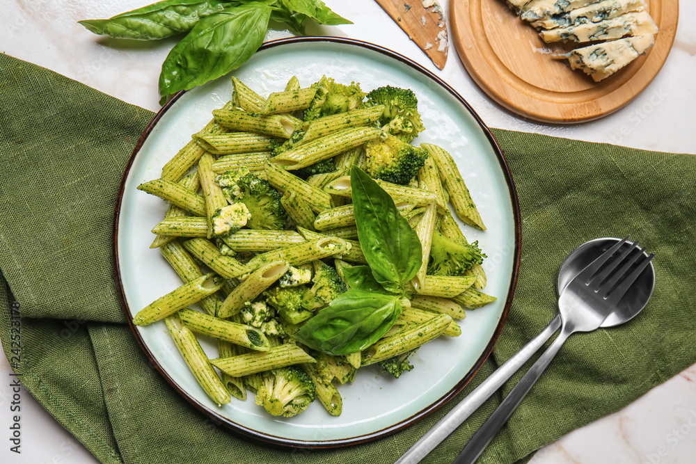 Plate with tasty pesto pasta on table