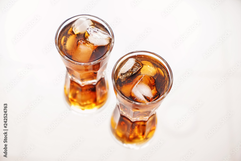Glasses of tasty cold cola drink on light table