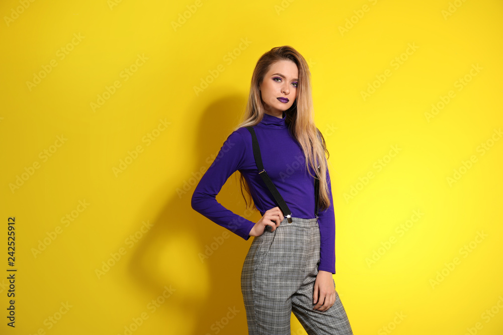 Fashionable young woman on color background