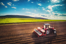 Farmer With Tractor Seeding Crops At Field, Aerial Drone View
