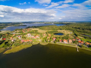 Poster - Aerial view of beautiful Ogonki village (former Ogonken or Schwenten, East Prussia) located on Swiecajty Lake shore, Mazury, Poland