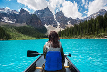 Tourist Canoeing On Moraine Lake In Banff National Park, Canadian Rockies, Alberta, Canada.