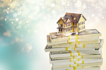 Canvas Print - Stack of money with house on background