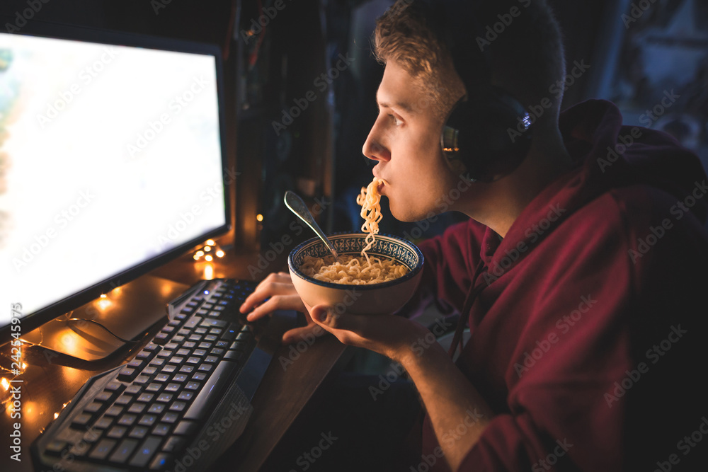 счастливый геймер за ноутбуком на кухне