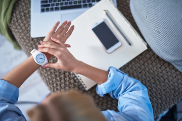 Young lady checking the time while working at home