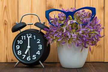 Wall Mural - Little tree in white vase with vintage alarm clock on wooden table