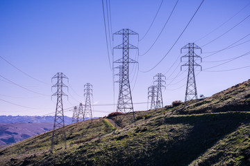 Wall Mural - High voltage electricity towers on a blue sky background, San Francisco bay area, California