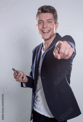 Fotografía Young cheerful guy smiling looking at smartphone