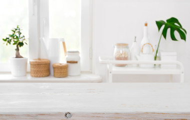 Wooden table on blurred background of kitchen window with utensils