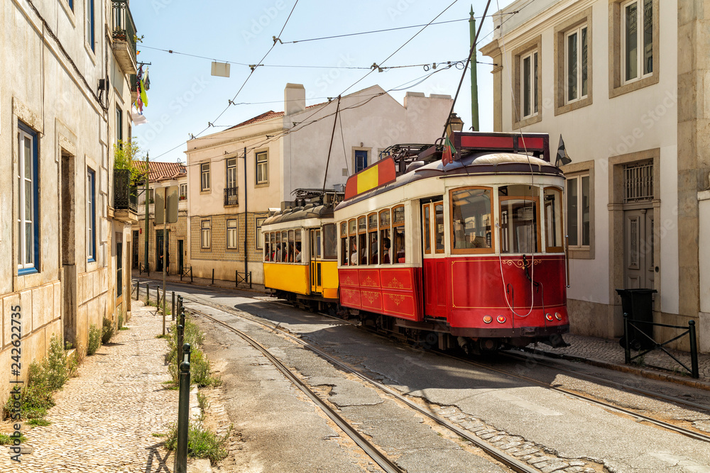 Yellow and red tram on old streets of Lisbon, Alfama, Portugal, popular touristic attraction and destination. - obrazy, fototapety, plakaty 