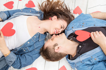 Valentine's day concept: couple in love laying down with red hearts shape