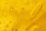 Abstract yellow background with oil drops and waves on water surface