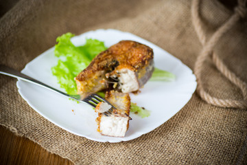 Wall Mural - piece of fried pike fish in a plate on a wooden