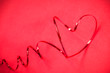 Beautiful luxury red heart shape from wire ribbon on red background and small heart use for valentines ‘s day concept.