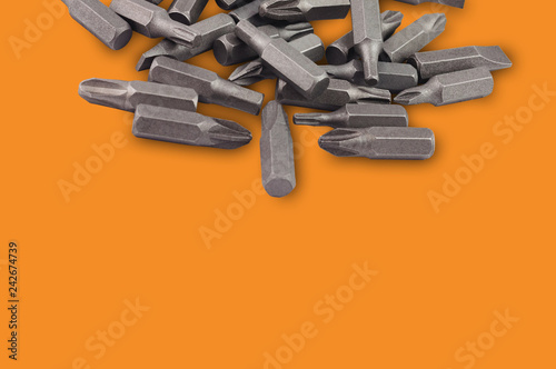 Fotografie, Obraz One heap of different interchangeable heads or bits for manual screwdriver for woodworking and metalworking on orange background with copy space for your text