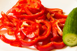 Fototapeta Kuchnia - Large sliced red sweet pepper and cucumber on white background