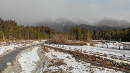 Wall Mural - Aerial panoramic view of mountain valley in winter with snow, forest and river