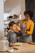 © cherryandbees - give me high five. little boy and his grandmother baking together in kitchen.