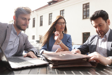 Sticker - business partners sit at a table on the street,