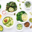 Green ingredients for spring detox salads: spinach, sorrel with red veins, cucumbers, radishes, iceberg lettuce, green peas, avocados, lemon, microgreen, yellow tomatoes on a white background with
