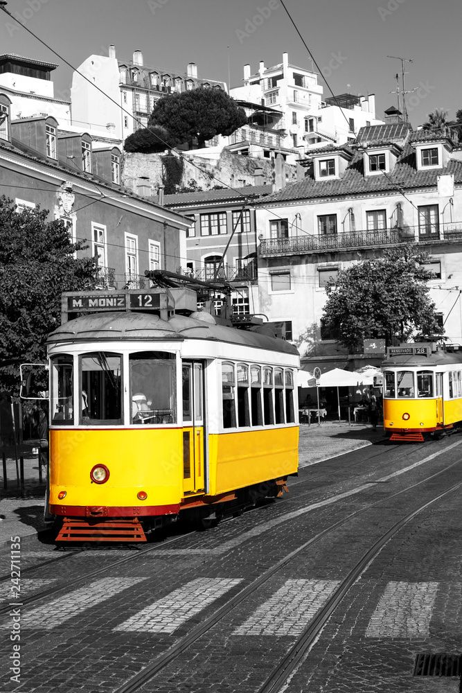 Yellow tram on old streets of Lisbon, Alfama, Portugal, popular touristic attraction and destination. Black and white picture with a coloured tram. - obrazy, fototapety, plakaty 