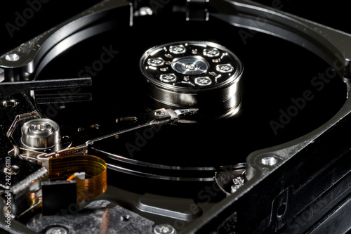 Fotografia Disassembled and opened hard disk drive, inside view with reflections, isolated