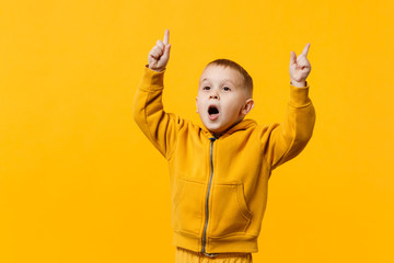 Wall Mural - Little cute kid boy 3-4 years old wearing yellow clothes isolated on bright orange wall background, children studio portrait. People sincere emotions, childhood lifestyle concept. Mock up copy space.