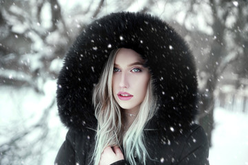 Winter portrait of young woman wearing jacket in nature