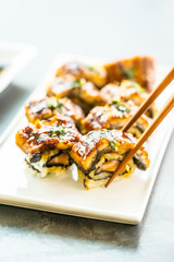 Wall Mural - Grilled eel or unagi fish sushi maki roll with sweet sauce